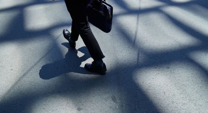 A man walking with a briefcase to his new job